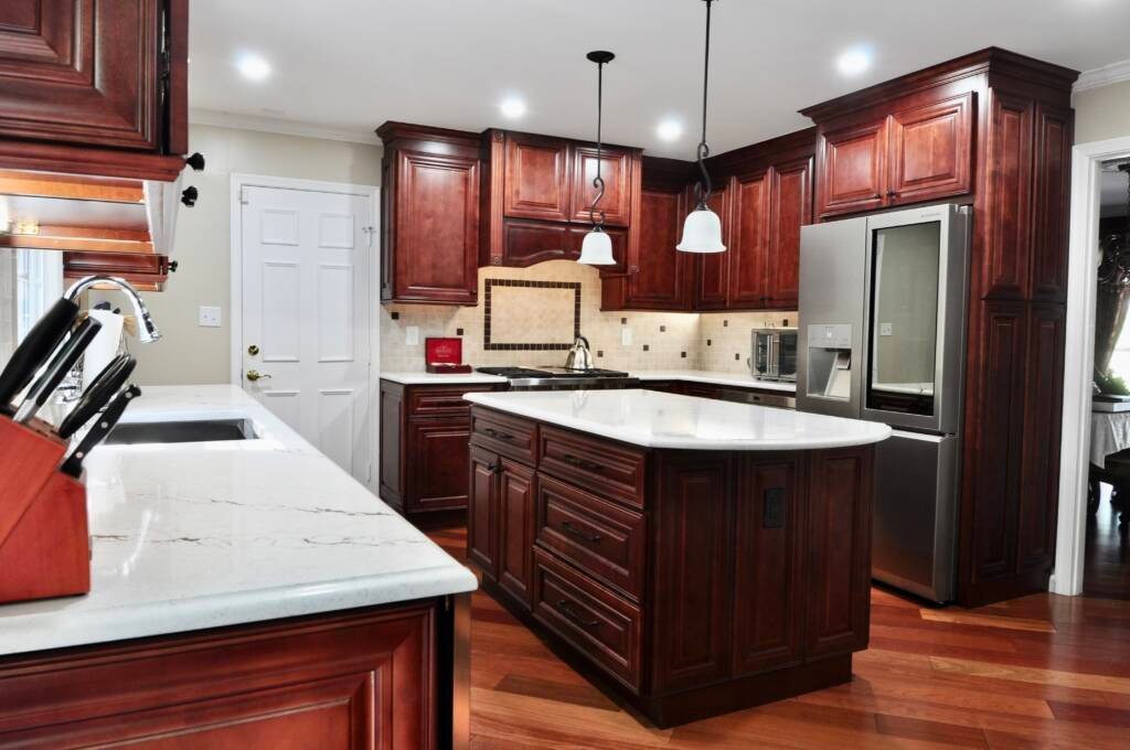 Cherry kitchen cabinets with a white island countertop